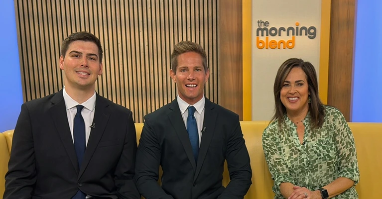 Pivot Work Injury Law attorneys sitting with The Morning Blend TV hosts on a yellow sofa during a talk show segment.