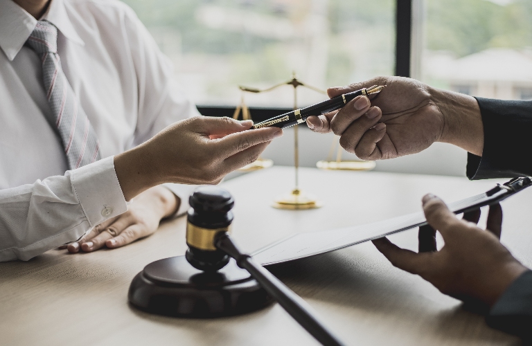 Attorney gives the client a pen to sign a contract