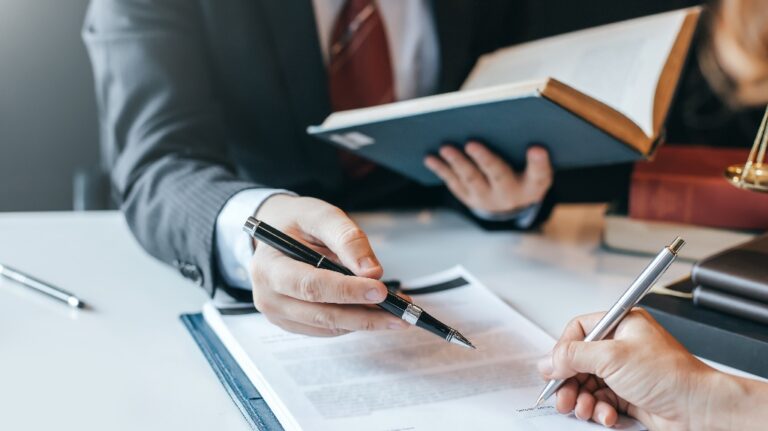 Lawyer is showing client where to sign document