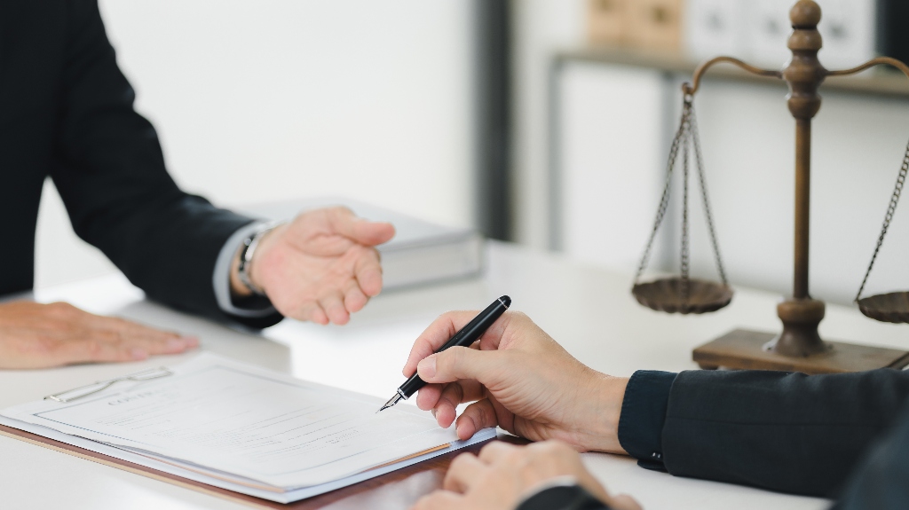 Lawyer is showing client where to sign documents