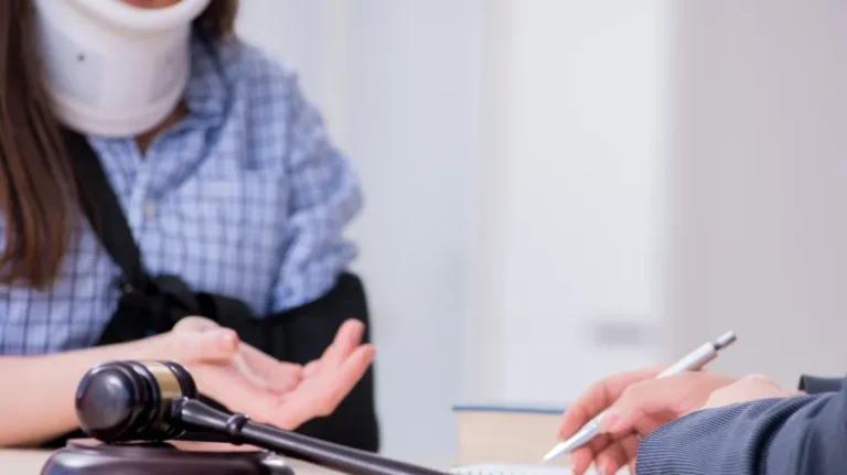 Injured woman wearing neck brace and arm sling consulting with legal professional.